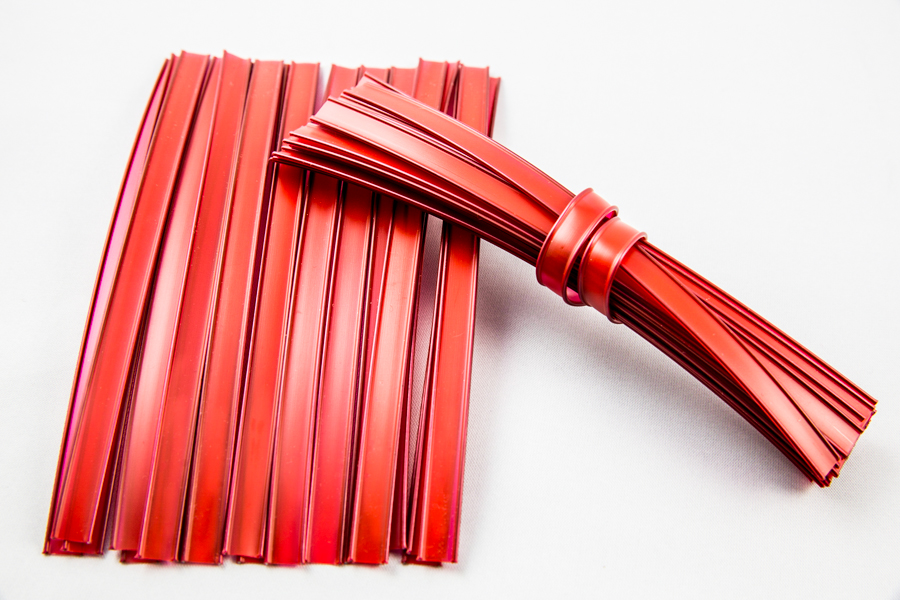 Cięty plastikowy clipband w czerwonym kolorze ułożony artystycznie