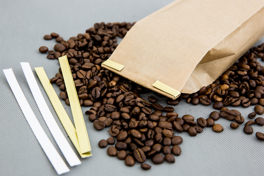 Opakowanie kawy zamknięte papierowym clipbandem w kolorze złotym
