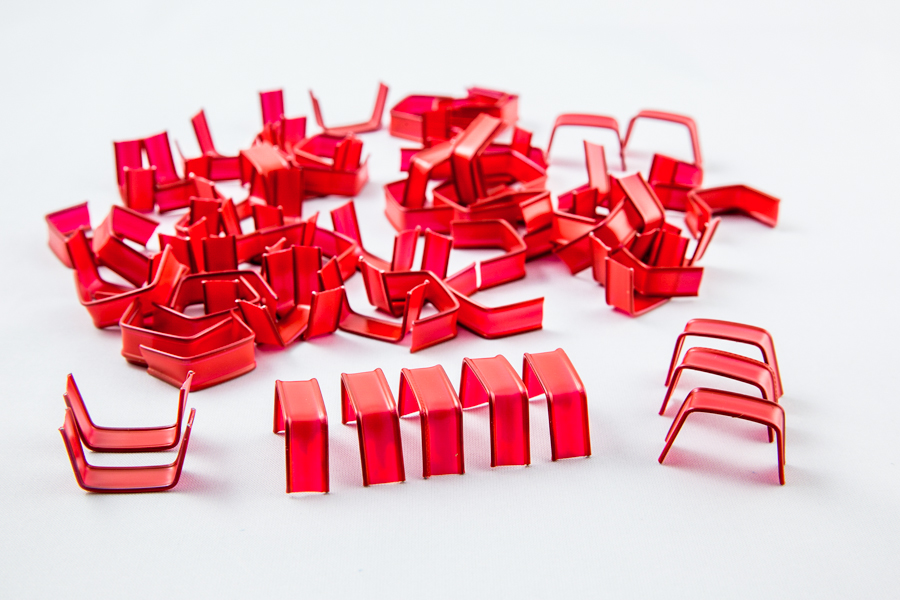 Plastikowe U-klipsy clipband w kolorze czerwonym ułożone artystycznie
