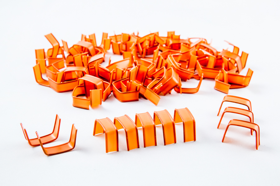 Plastikowe U-klipsy clipband w kolorze pomarańczowym ułożone artystycznie
