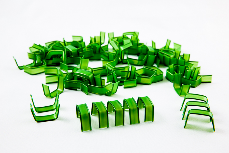 Plastikowe U-klipsy clipband w kolorze zielonym ułożone artystycznie