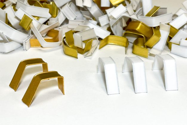 Cięty papierowy clipband w kolorze złotym i białym ułożony artystycznie